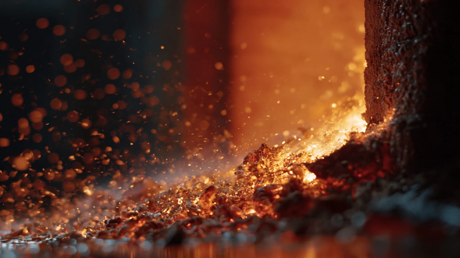 Sparks streaming from molten metal at the forge